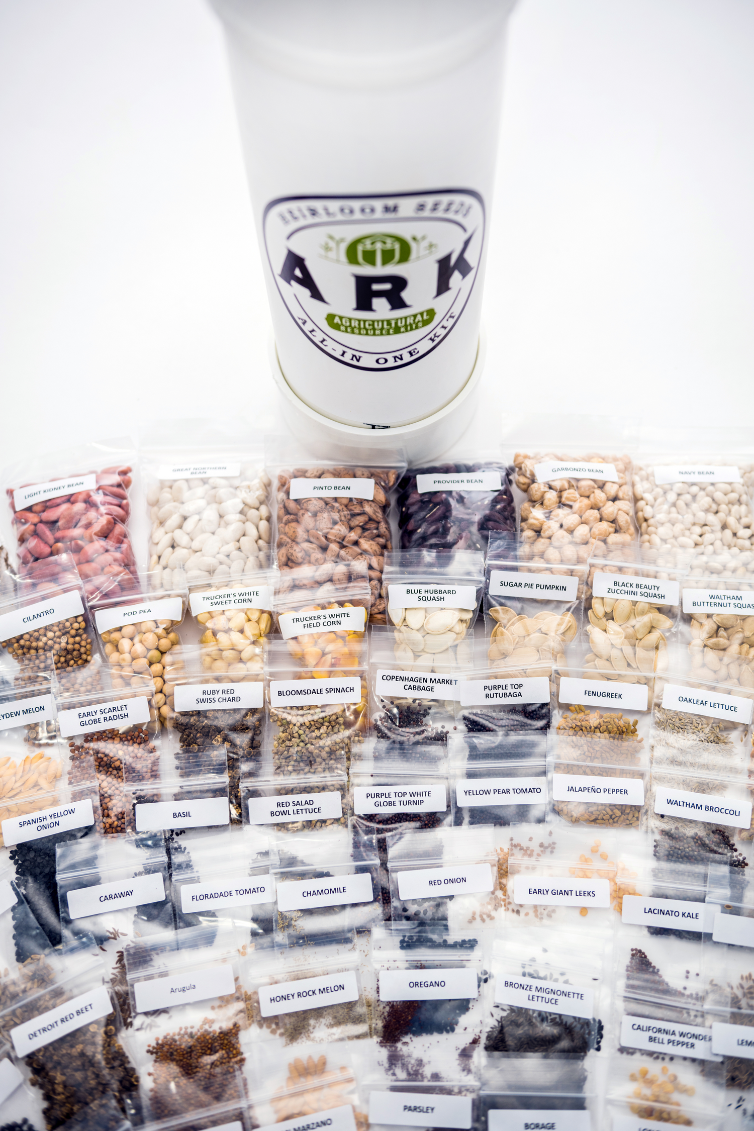 Assorted seeds in labeled containers with a white container labeled 'ARK' on a white background.