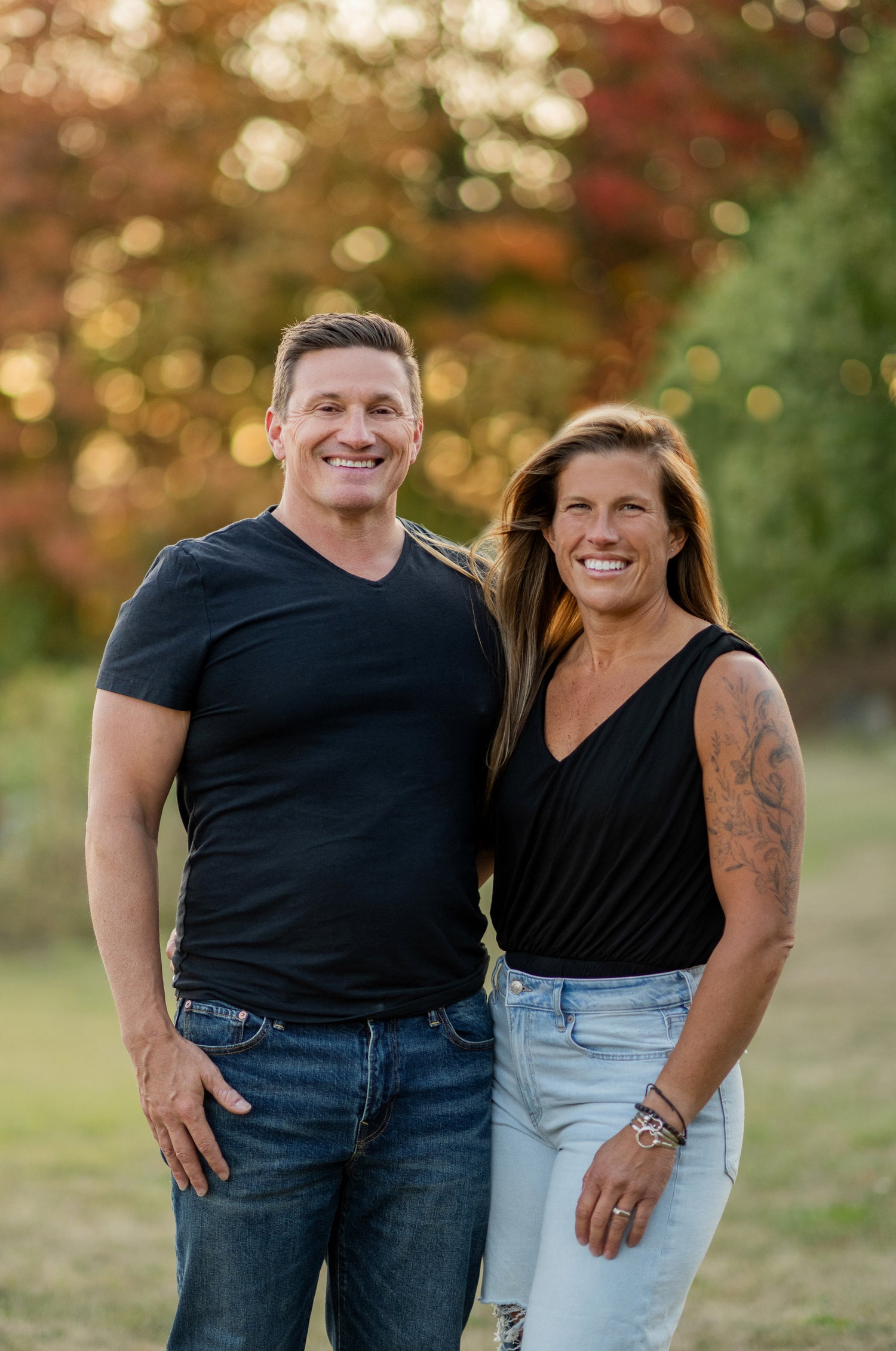 Man and woman standing together outdoors with a blurred natural background